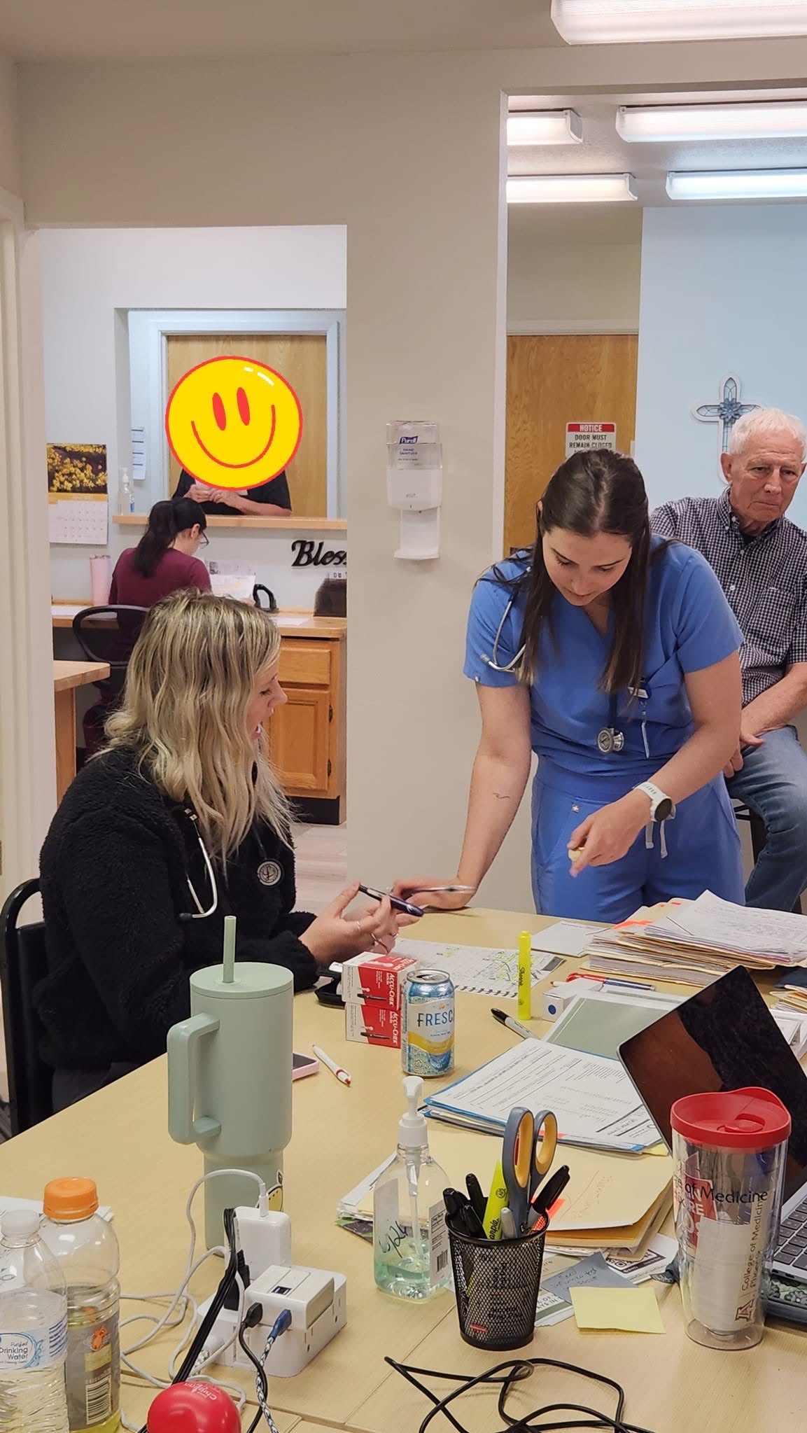 Medical trainees collaborating over patient charts at the clinic